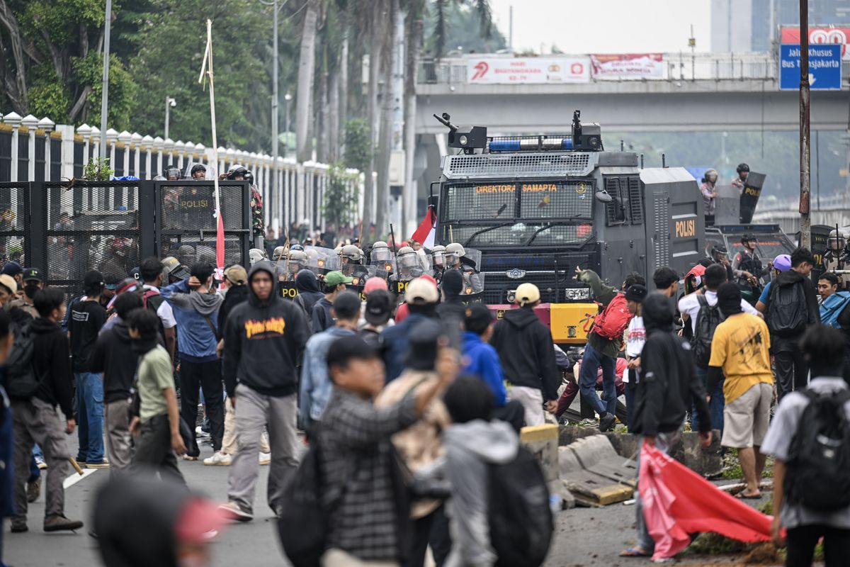 Personel polisi menghalau pengunjuk rasa yang demo di Jalan Letjend S Parman, depan Gedung DPR, Jakarta, Senin (25/8/2025).