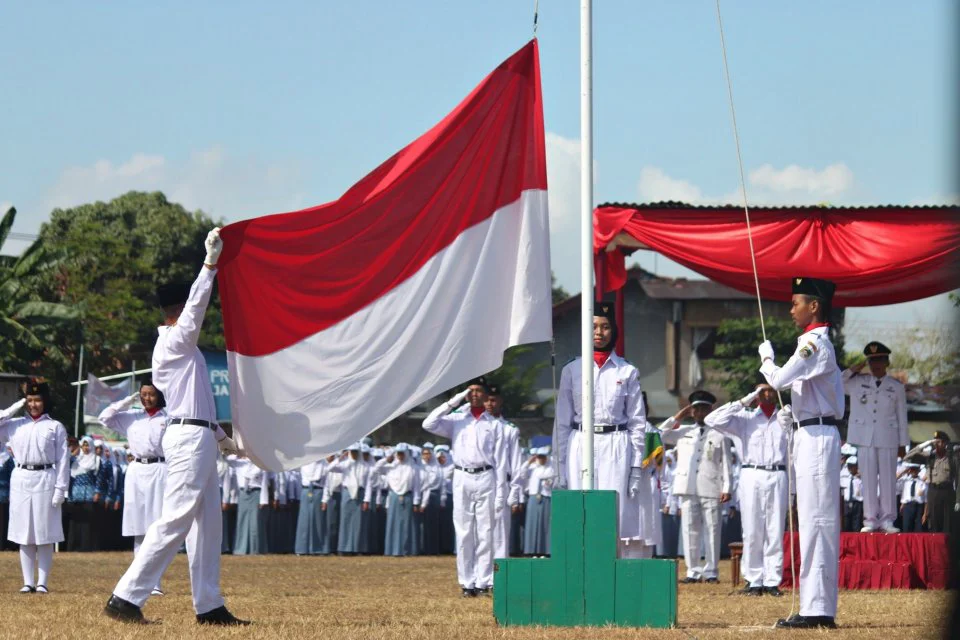 Ilustrasi pengibaran bendera merah putih sebagai wujud nasionalisme.